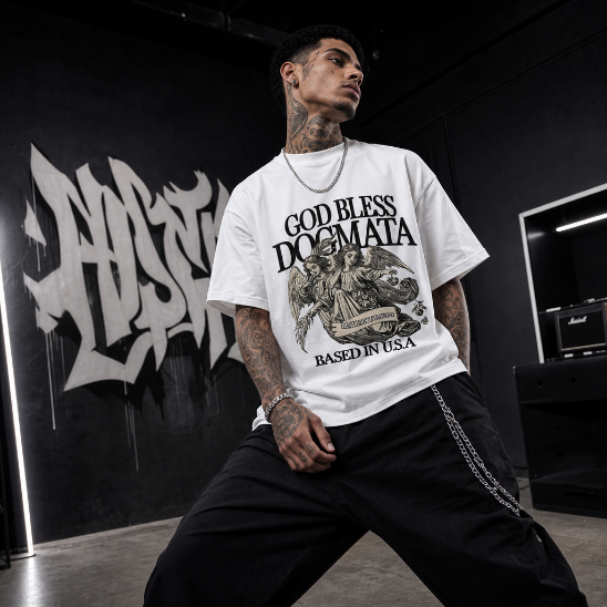Model wearing a white t-shirt with graphic design and text, sitting in a room with black walls and musical equipment.